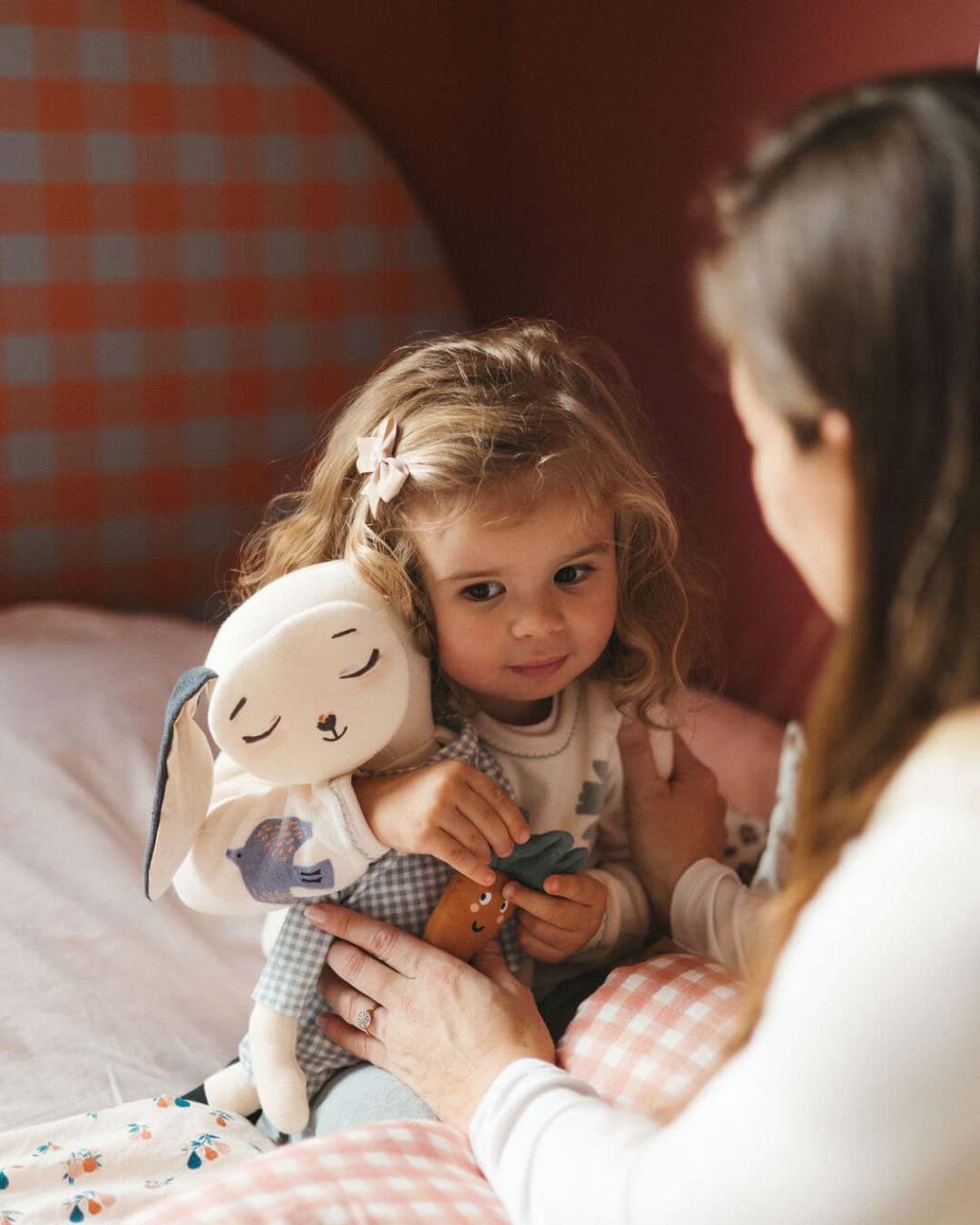 petite fille fait un calin à pipouette dans son lit